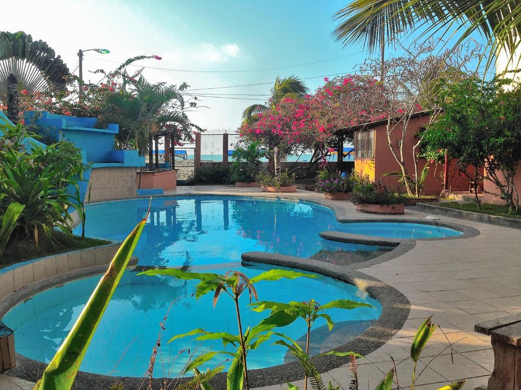 a swimming pool in a yard with trees and plants at Cabañas Ecologicas Cayapas in Atacames