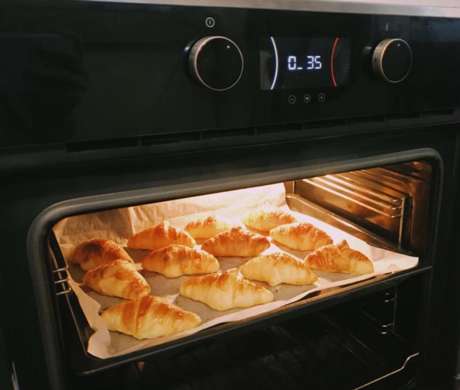 Fresh pastries baking in a modern built-in oven.