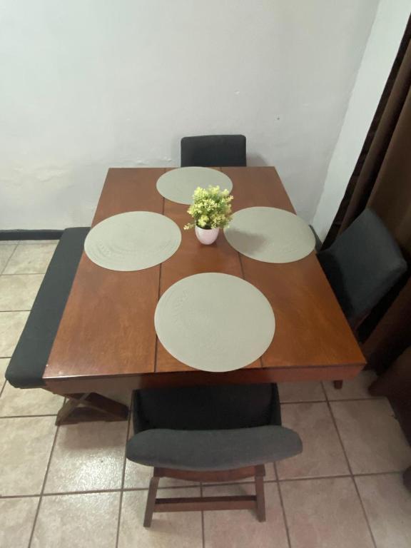a wooden table with four chairs and a plant on it at Casa Tlaxcala in Ciudad Obregón