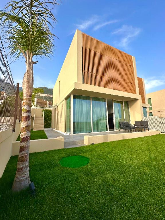 a house with a palm tree in a yard at Queens Luxury Vila 111B in Vlorë