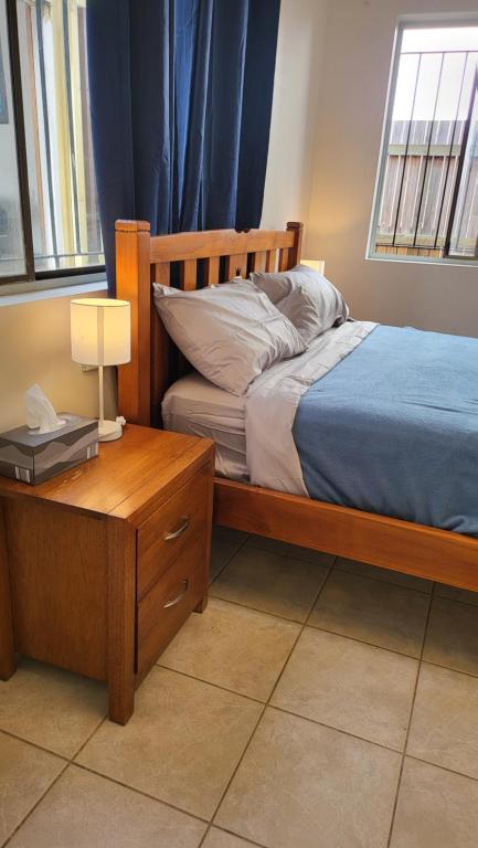 a bedroom with a bed and a table with a lamp at The Gabba B&B in Brisbane