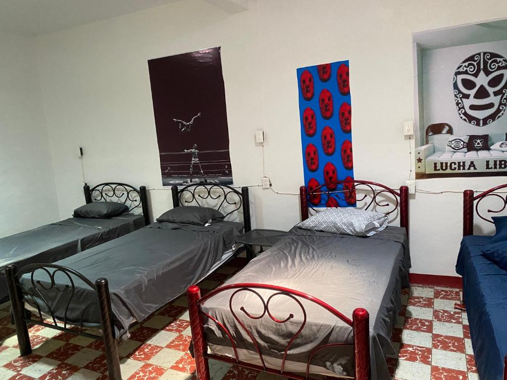 a room with two beds and a flag on the wall at Hostal Mil Máscaras in Oaxaca City