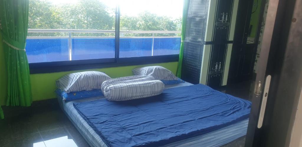 a room with two beds in a room with a window at Villa GeGe Puncak in Cipayung