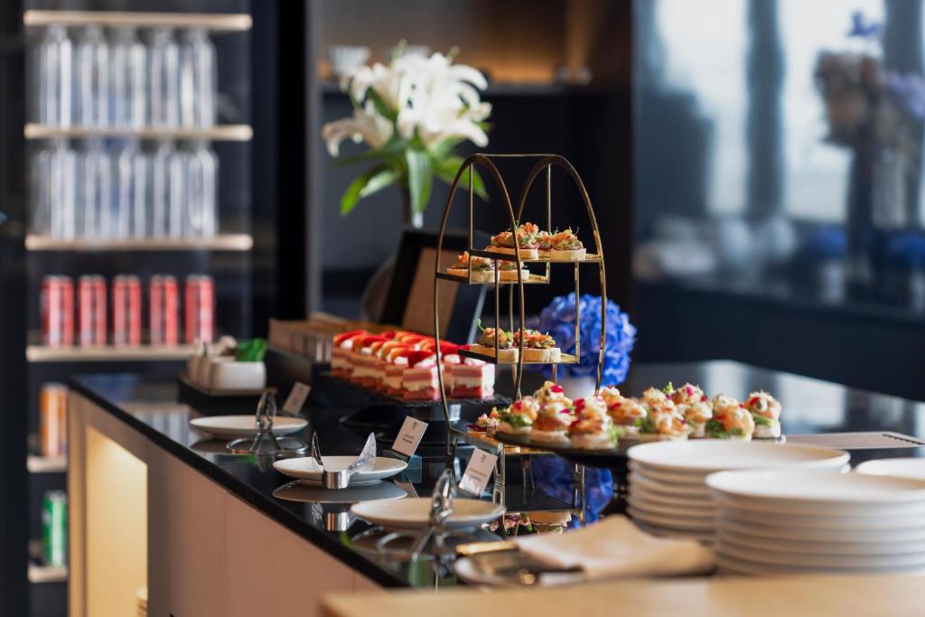 A styled buffet display of desserts and small savoury bites with plates ready for service.