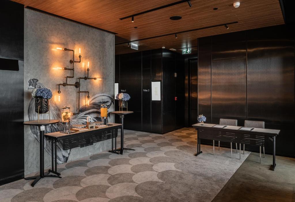 A dark, design-led event foyer with illuminated floral displays and meeting-room access.