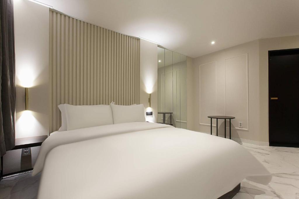 Postel nebo postele na pokoji v ubytování Grazie Hotel Tanhyeon