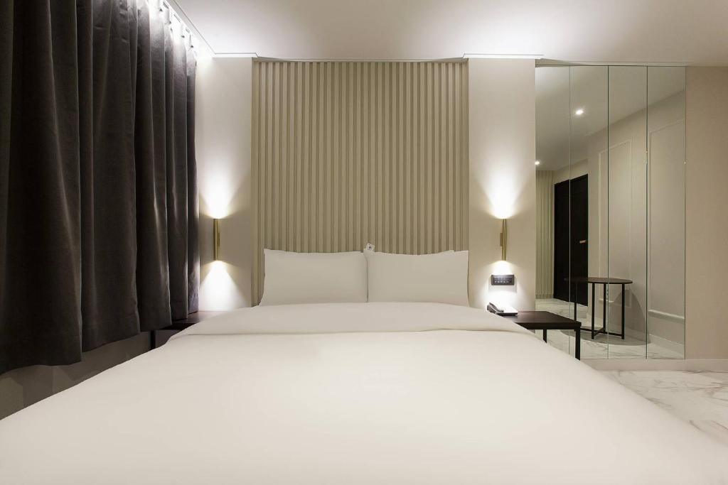 Postel nebo postele na pokoji v ubytování Grazie Hotel Tanhyeon