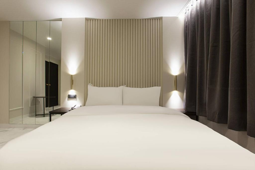Postel nebo postele na pokoji v ubytování Grazie Hotel Tanhyeon
