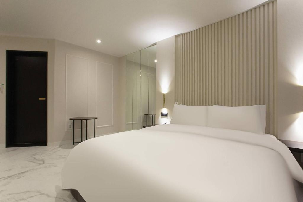 Postel nebo postele na pokoji v ubytování Grazie Hotel Tanhyeon