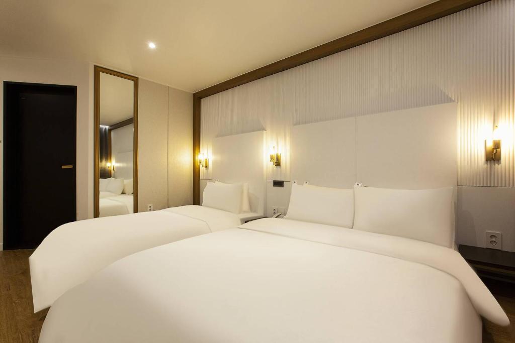 Postel nebo postele na pokoji v ubytování Grazie Hotel Tanhyeon