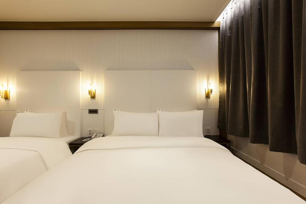 Postel nebo postele na pokoji v ubytování Grazie Hotel Tanhyeon