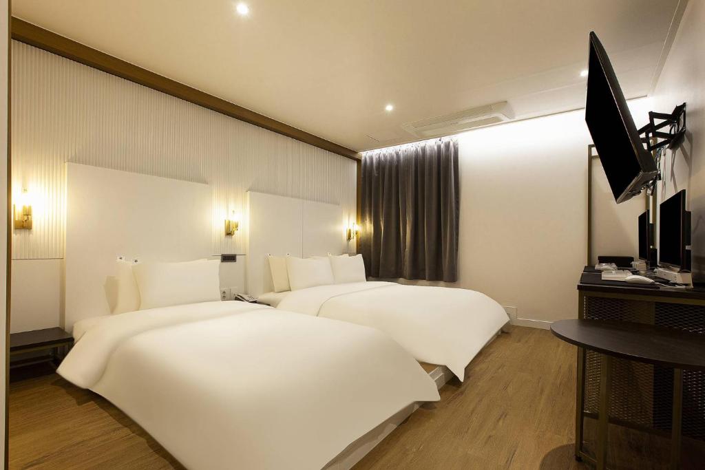 Postel nebo postele na pokoji v ubytování Grazie Hotel Tanhyeon