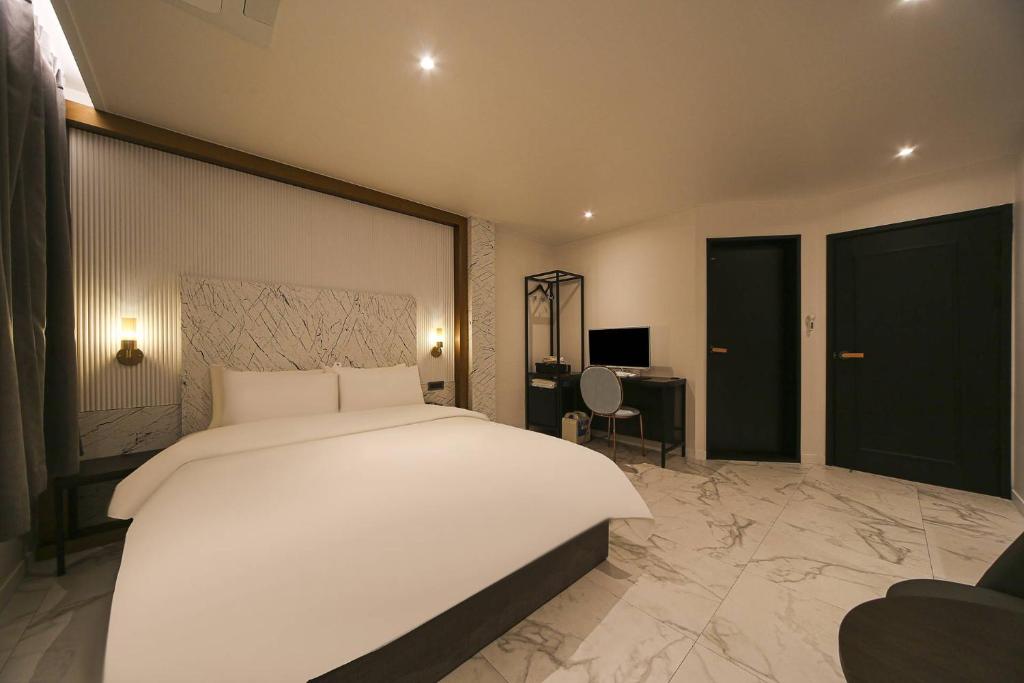 Postel nebo postele na pokoji v ubytování Grazie Hotel Tanhyeon