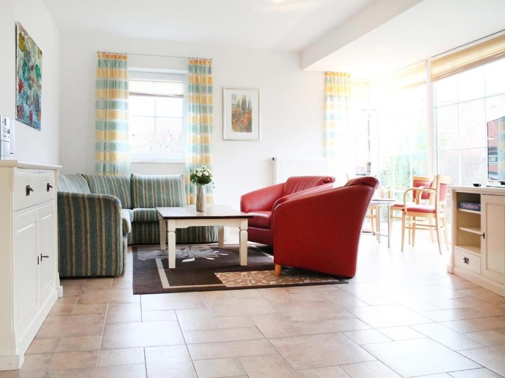 a living room with a red couch and a table at Ostseeblick Ferienhaus in Barendorf