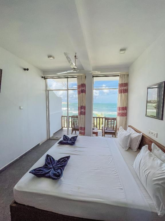 Postel nebo postele na pokoji v ubytování New Wave Beach Resort Unawatuna