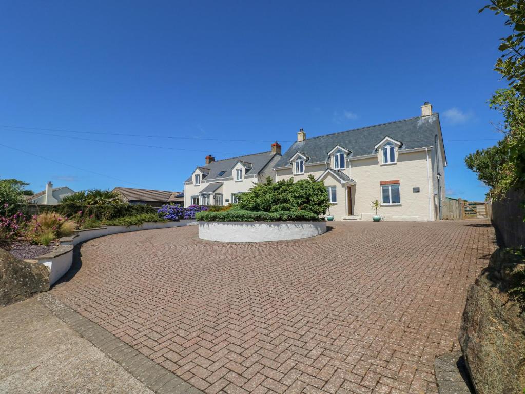 Una gran casa blanca con una entrada de ladrillo en Llain Gwynfor, en Haverfordwest