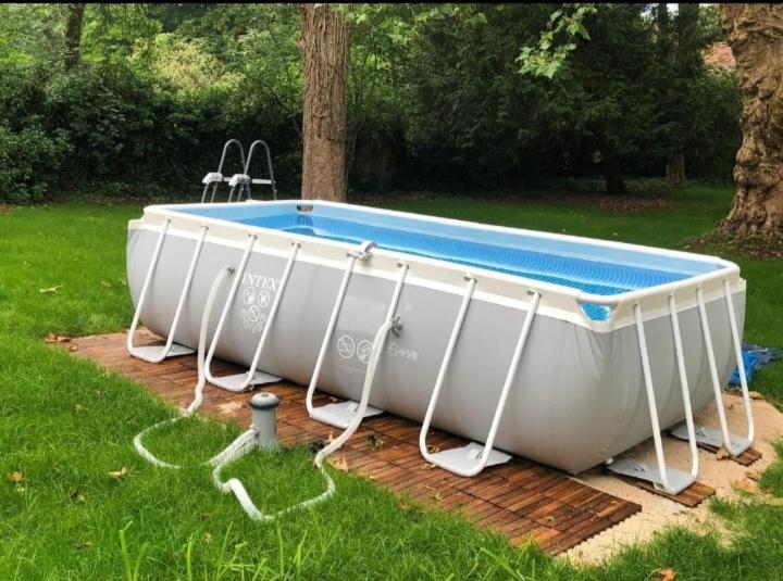 ein weißes Boot, das im Gras in einem Hof liegt in der Unterkunft Maison de famille Jacqueline in Vitteaux