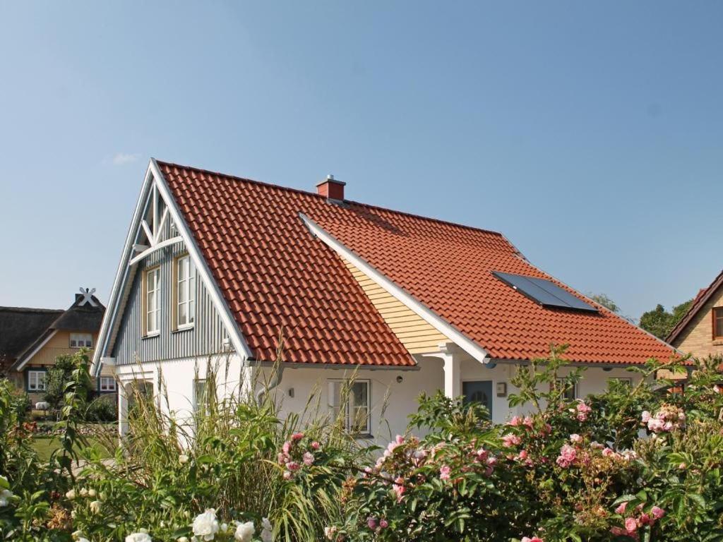 a white house with an orange roof at Smutje, Ferienhaus in Groß Schwansee