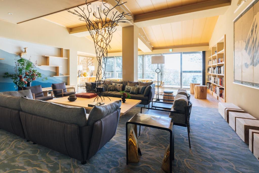 a living room with couches and a table at Suite Villa Curation Atami Momoyamagaen in Atami