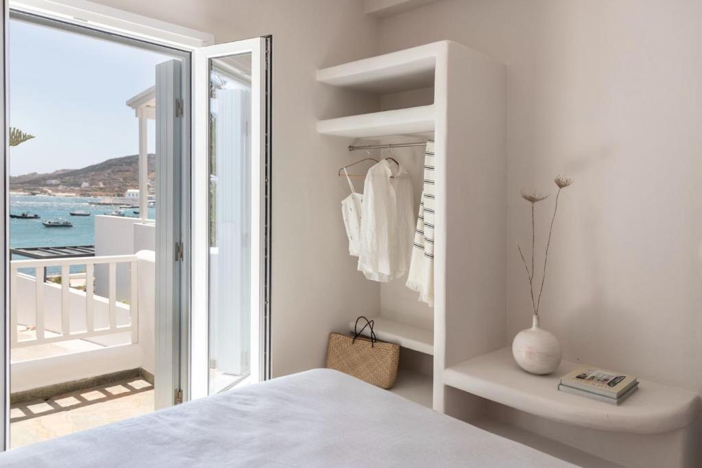 a white bedroom with a view of the ocean at Om Living Milos in Pollonia