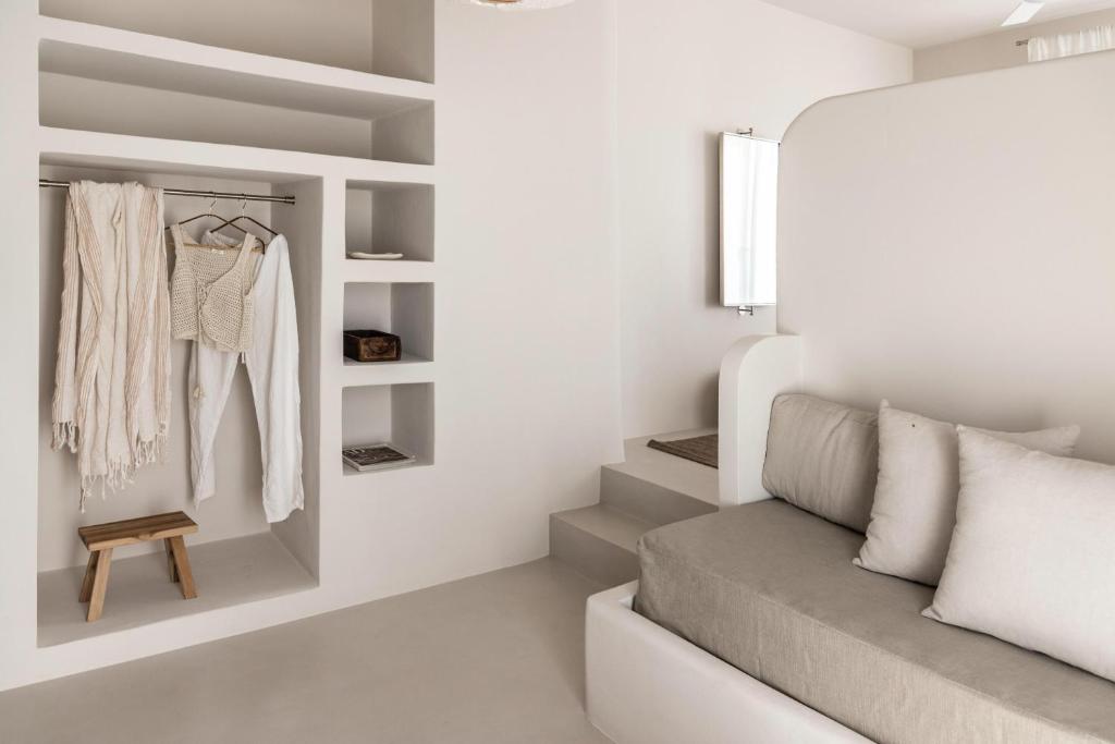 a room with white walls and a couch at Om Living Milos in Pollonia