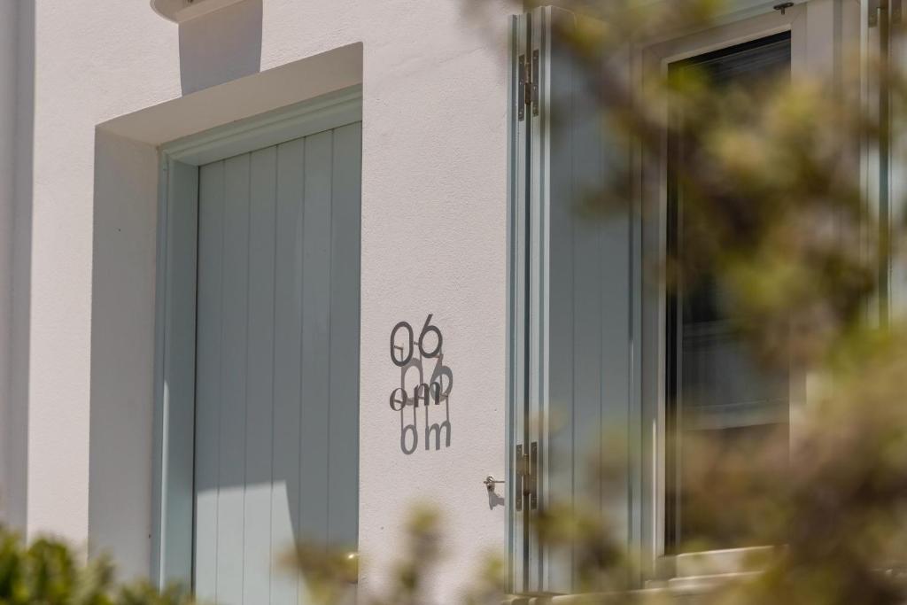 a door to a garden club sign on a building at Om Living Milos in Pollonia