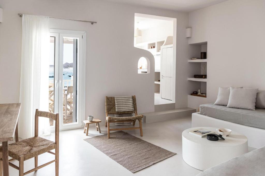 a white living room with a couch and a table at Om Living Milos in Pollonia