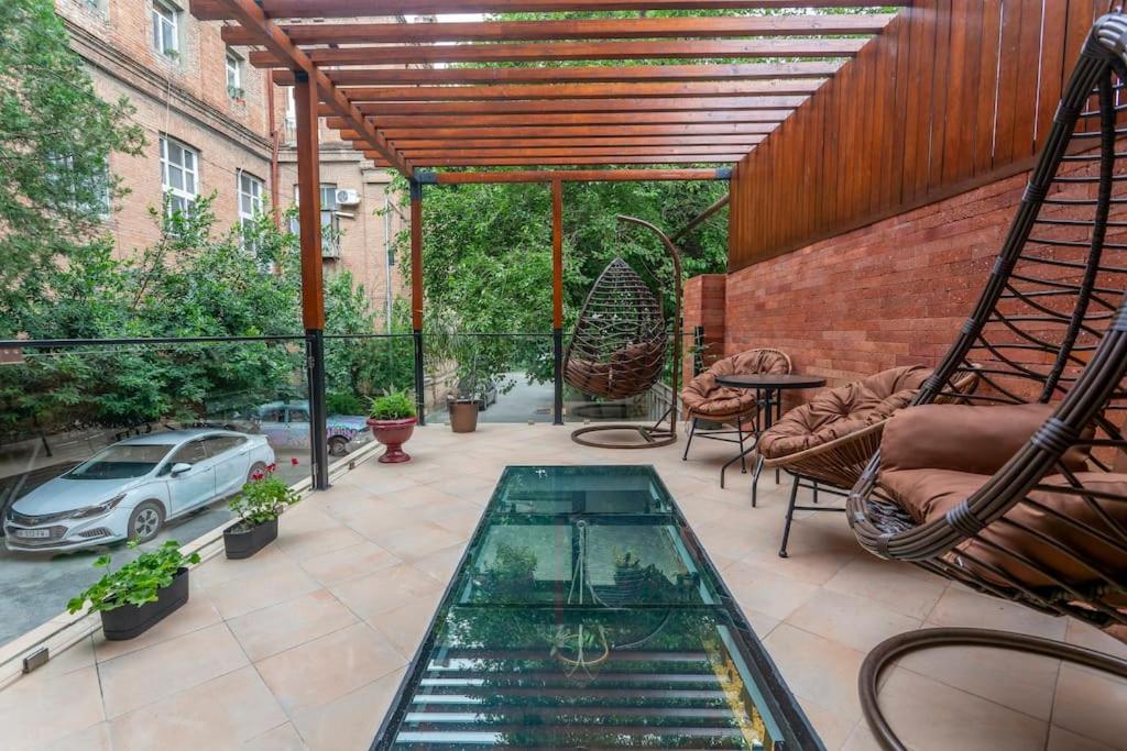 an outdoor patio with a glass table and chairs at Condo in center Tbilisi with Terrace in Tbilisi City
