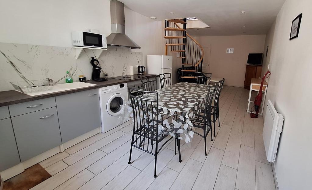 une cuisine avec une table et des chaises dans une cuisine dans l'établissement maison avec terrasse du valleroy, à Joinville