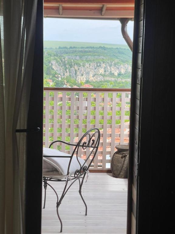 a chair sitting on a balcony with a view at Ethno Villa Cherry in Cherven