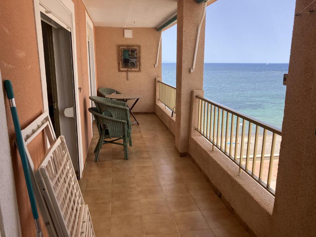 Un balcón con mesa y sillas y el mar. en Zambra 3 - 411, en La Manga del Mar Menor