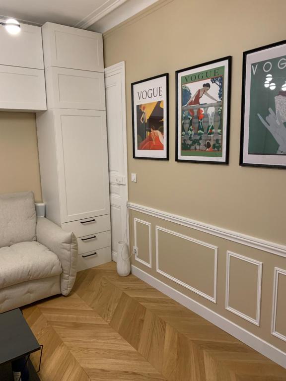 - un salon avec un canapé et des photos sur le mur dans l'établissement Super Apartment, comfort design functional, à Paris