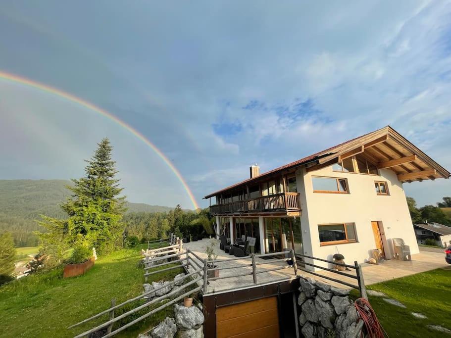 a large house with a rainbow in the background at Traumhaus sensationeller Lage Traumhafter Bergblick absolute Ruhe in Fischbachau