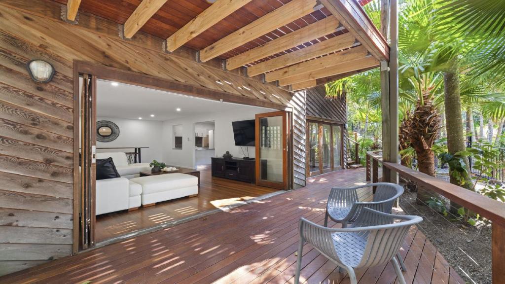 a living room with a couch and chairs on a wooden deck at Kasuari - Just Steps to Pool and Beach in Coffs Harbour