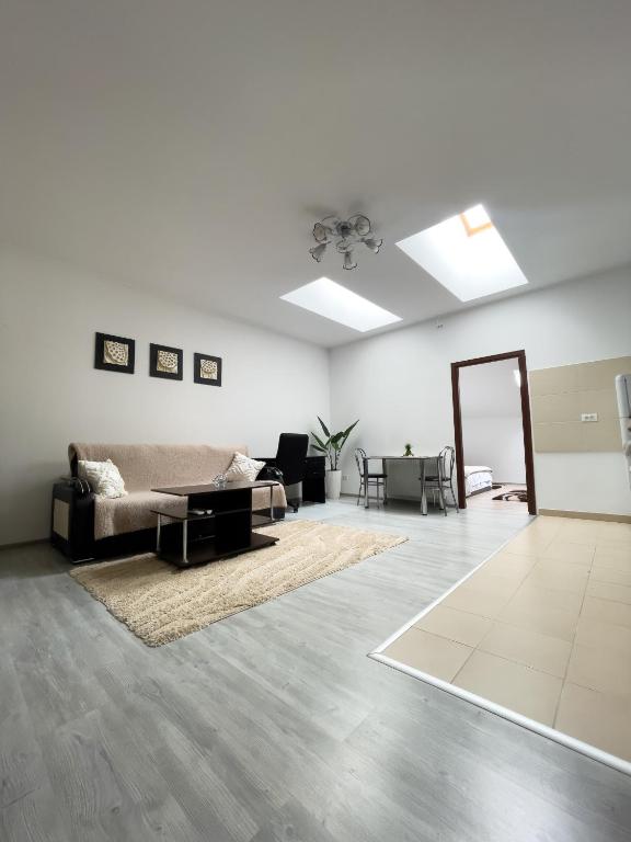 a living room with a couch and a mirror at Enjoy Apartments - Central Skylight Residence in Cluj-Napoca