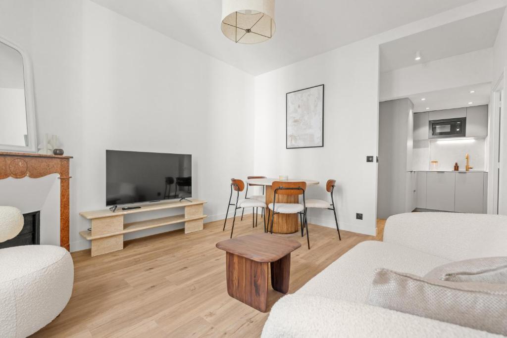 un salon avec un canapé et une table dans l'établissement LB Vacation Rentals I Renovated Apartment Min from Beach and Palais, à Cannes