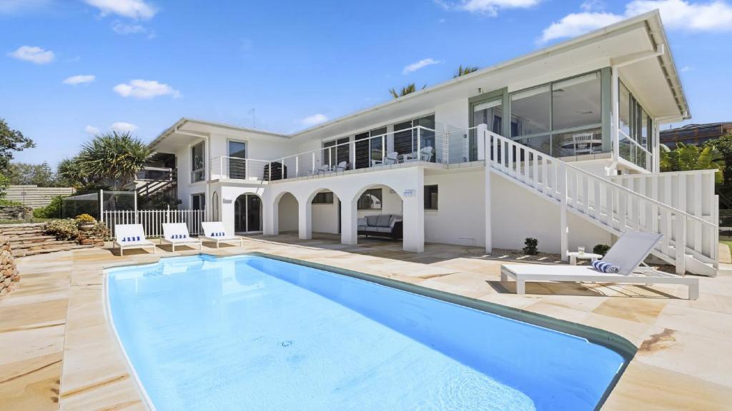 a large house with a swimming pool in front of it at Captain's Quarters - Absolute Beachfront, Pool, Pets, Family Friendly in Sapphire Beach