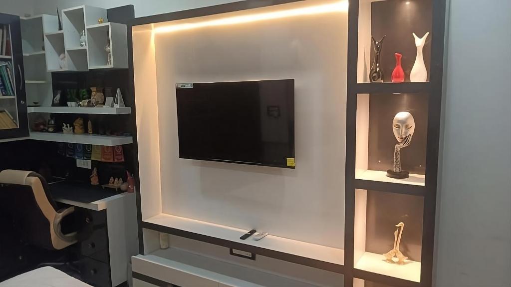 - un centre de divertissement avec une télévision murale à écran plat dans l'établissement The Great Escape - Rustic Countryside Stay, à Amritsar