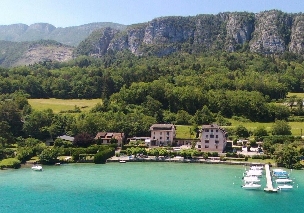 eine Luftaufnahme eines Resorts mit Booten im Wasser in der Unterkunft Le Nid du Lac, appartement en duplex au bord du lac d'Annecy, résidence avec plage privée in Doussard