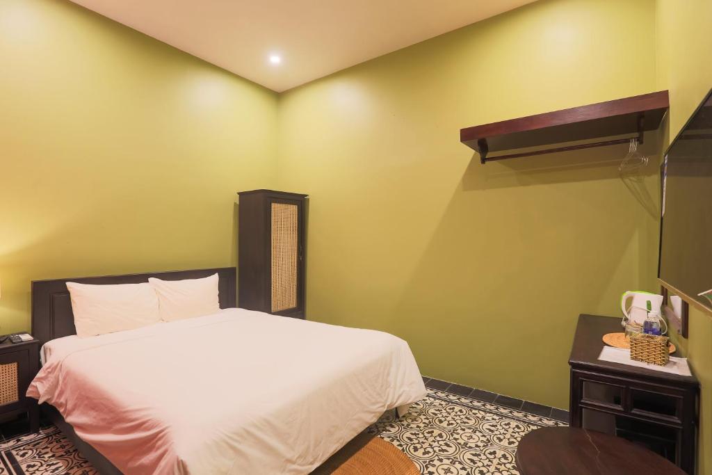 A double bedroom offers a compact setup with a desk, drinks station, and open clothing rail.