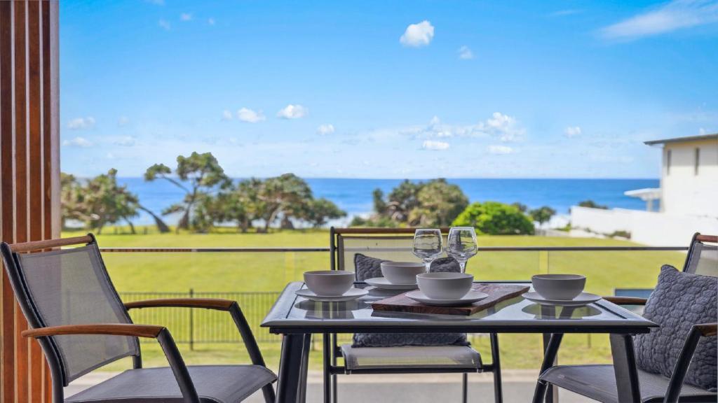 a table and chairs with a view of the ocean at Oceanfront View - Pizza Oven, Pool, Beach in Sapphire Beach