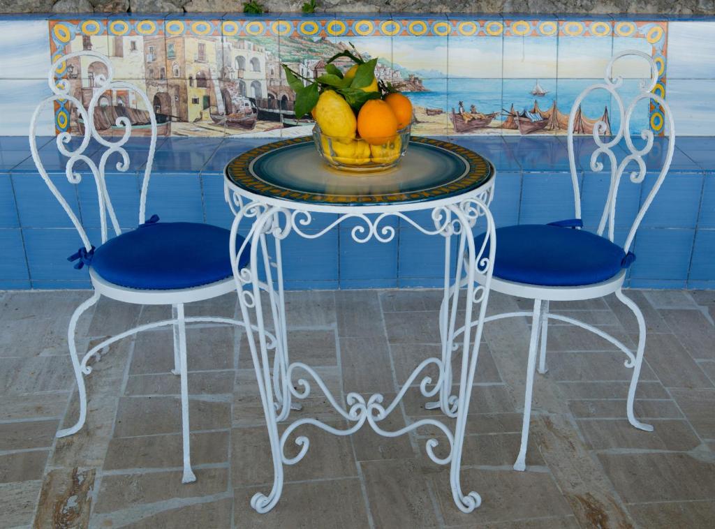 a table with two chairs and a bowl of fruit on it at Hotel Aurora in Amalfi
