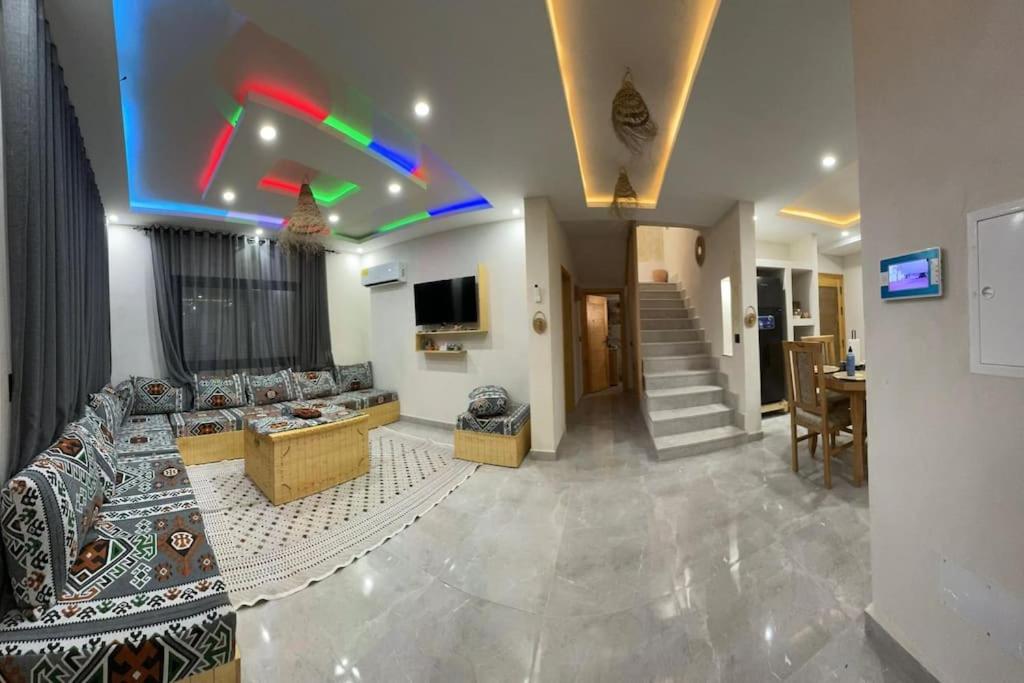 een woonkamer met een bank, een tv en een trap bij Dar FATMA in Houmt Souk