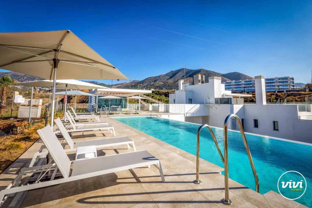 una vista della piscina di un hotel con sedie e un ombrellone di Penthouse Diamond - Private Pool, Terrace, Sea View, Gym & BBQ a Las Lagunas Mijas