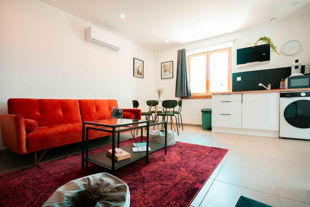 un salon avec un canapé rouge et une table dans l'établissement Studio 7 au coeur de la ville avec Parking, à Aix-les-Bains