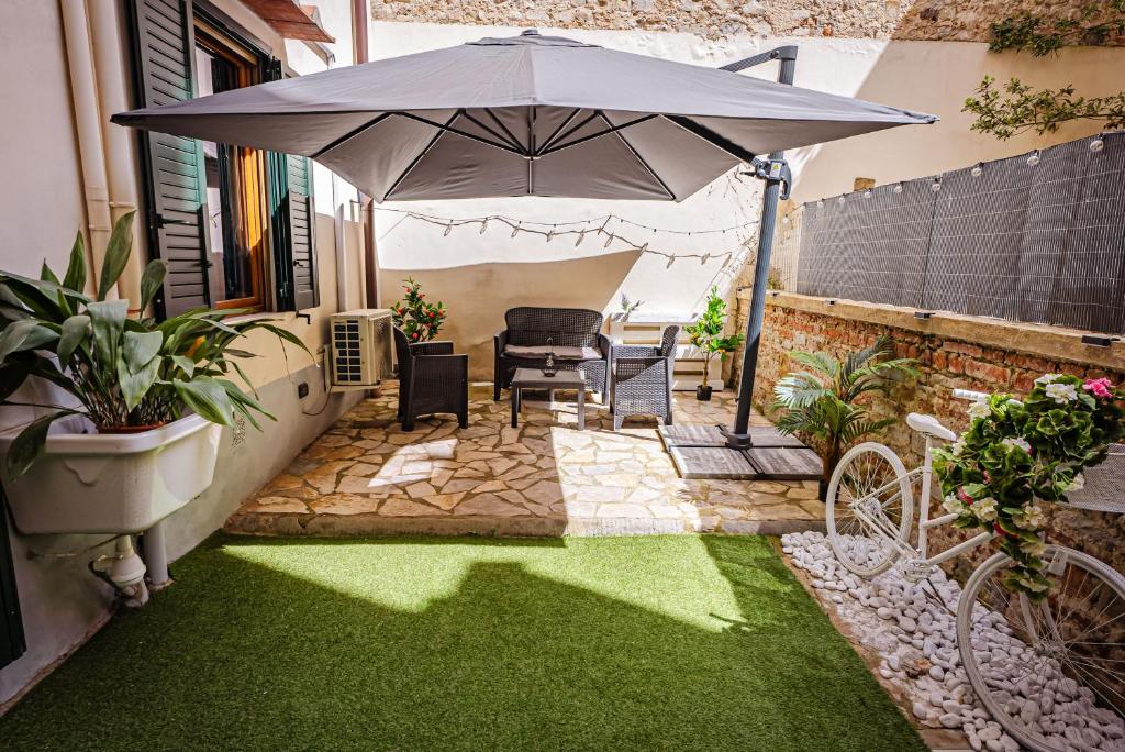 a patio with an umbrella and green grass at Florence Garden Suite in Florence
