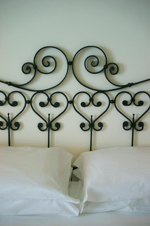 a metal headboard with white pillows on a bed at Hotel Aurora in Amalfi