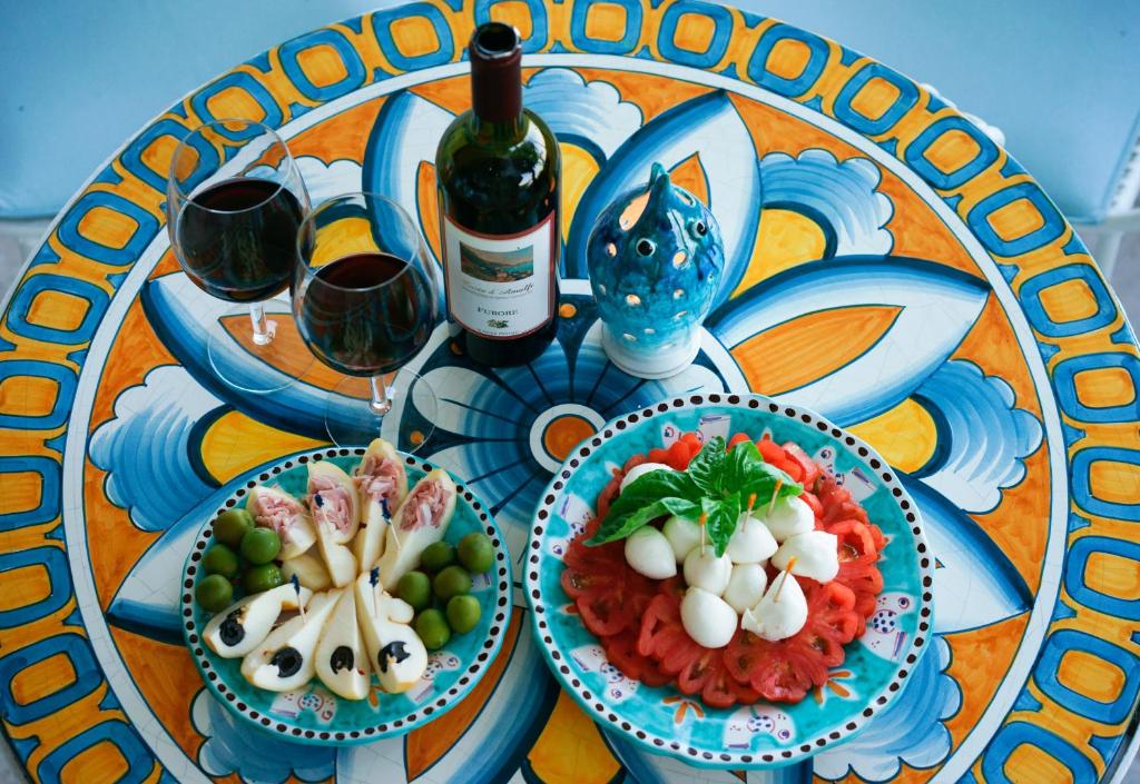 a table with two plates of food and a bottle of wine at Hotel Aurora in Amalfi