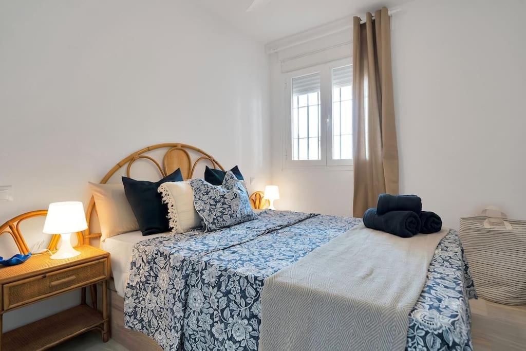 ein Schlafzimmer mit einem Bett mit einer blau-weißen Decke in der Unterkunft Duplex marinero con vista al mar gimnasio piscina - LAS ABEJERAS 615 in Estepona