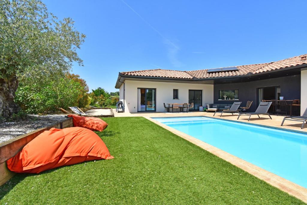 a yard with a swimming pool and a house at Villa Miluva - Maison climatisée avec piscine in Lapeyrouse-Fossat